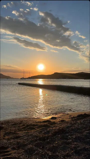 Coucher de soleil sur une baie grecque, voiliers au mouillage devant les collines