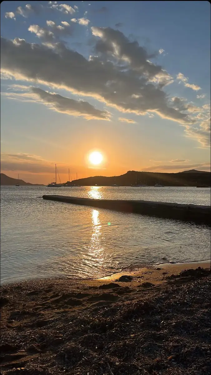 Coucher de soleil sur une baie grecque, voiliers au mouillage devant les collines