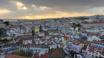 Toits de Lisbonne au couchant vus d'un belvédère, le Tage à l'horizon
