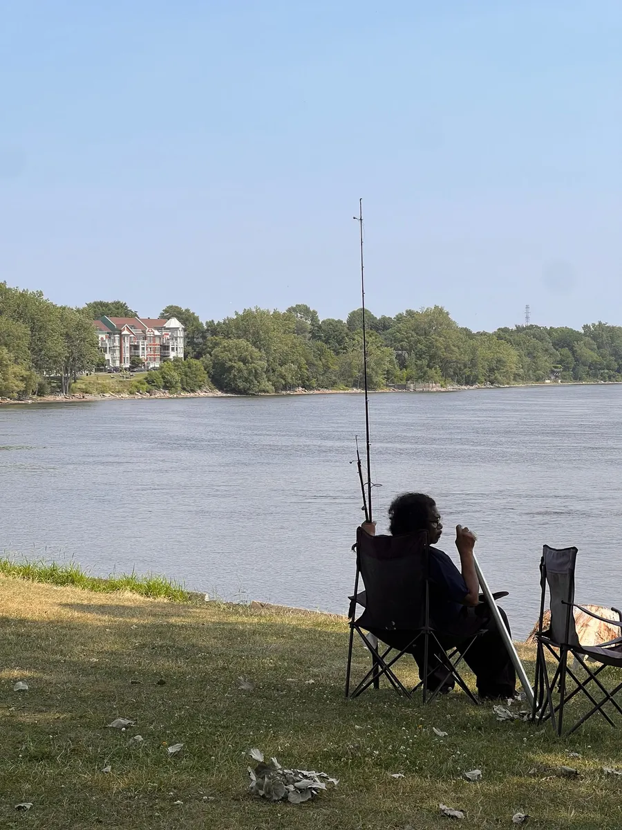 Pêcheur installé en chaise pliante au bord du Saint-Laurent, Montréal